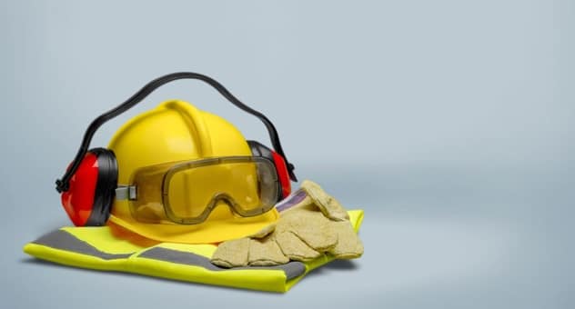 Hard hat, protective gloves, hi-vis jacket, goggles and ear defenders arranged in pile