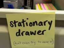  A yellow post-it that reads 'stationary drawer - don't even try to move it.