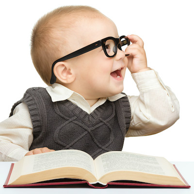 Laughing little kid in oversized glasses with a book