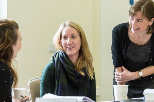 Delegates talk with the trainer during their business-writing course