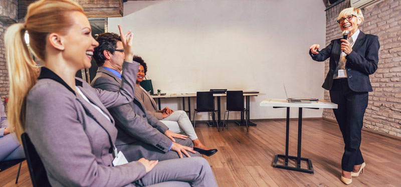 A businesswoman presenting points to a smiling member of the audience