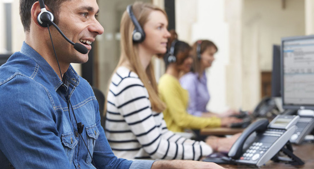 People working in a customer support centre on headsets.