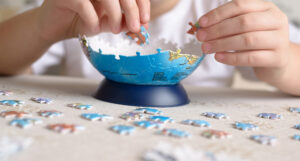 A person building a 3D jigsaw puzzle of Earth.