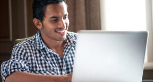 Smiling man at laptop