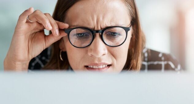 Woman,,Online,And,Confused,In,Office,For,Reading,Miscommunication,,Unclear Woman in glasses, looking at screen and frowning